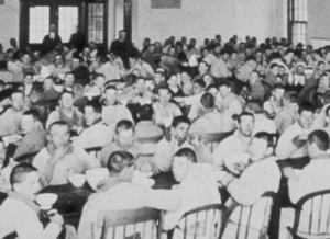 Hundreds of inmates gather for a meal in an institution, circa early 1900s